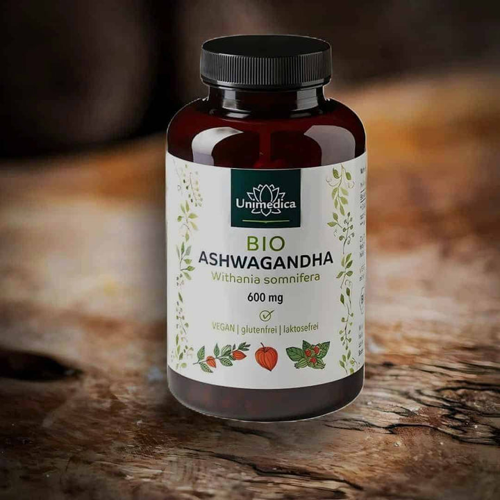 Ein Glas BIO Ashwagandha-Pulver mit 180 Kapseln auf einem Olivenholzbrett.