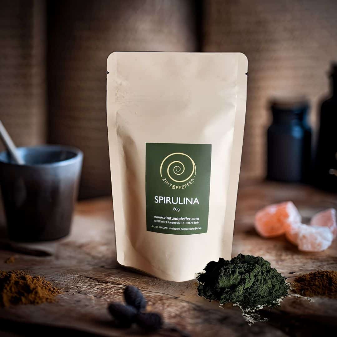 Spirulina Pulver von Zimt&Pfeffer in 
einer 80 g Tüte Spirulina Pulver auf einem Olivenholzbrett