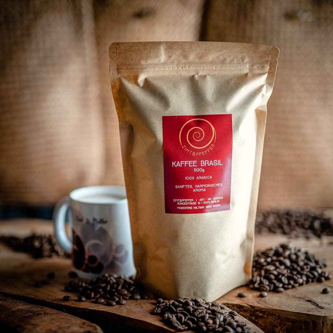 Eine 500g Tüte mit ganzen Bohnen Kaffee Brasil auf einem Olivenholzbrett.