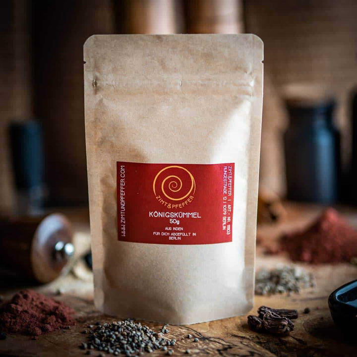 Eine Tüte mit 50g  Königskümmel auch Ajowan genannt auf einem Olivenholzbrett.