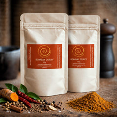 Bombay Curry von Zimt&amp;Pfeffer, zwei 50 g Tüten auf einem Olivenholzbrett