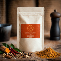 Bombay Curry von Zimt&amp;Pfeffer, eine 50 g Tüte auf einem Olivenholzbrett