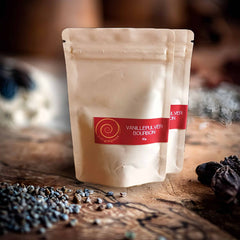 Bourbon Vanille Pulver aus Madagaskar – 100 % natürlich. Zwei 10g Tüten Bourbon Vanille Pulver auf einem Olivenholzbrett.
