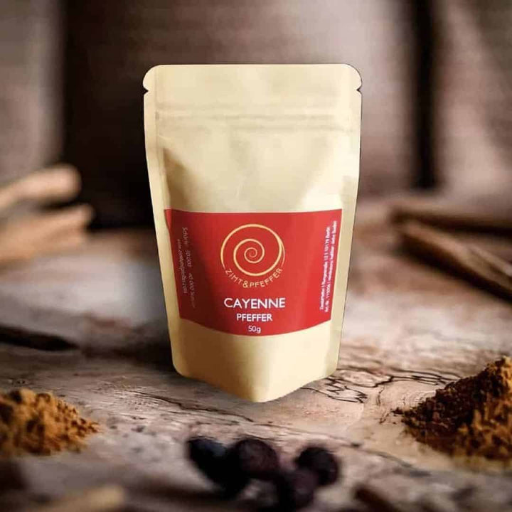 Eine Tüte Cayenne Pfeffer auf einem Olivenholzbrett.