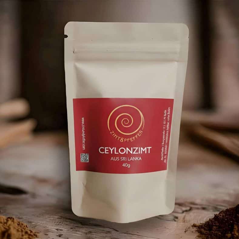Ceylon Zimtpulver in einer 40 g Tüte auf einem Olivenholzbrett.