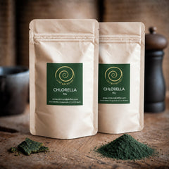 Chlorella Pulver von Zimt&amp;Pfeffer in zwei Tüten mit 80 g auf einem Olivenholzbrett