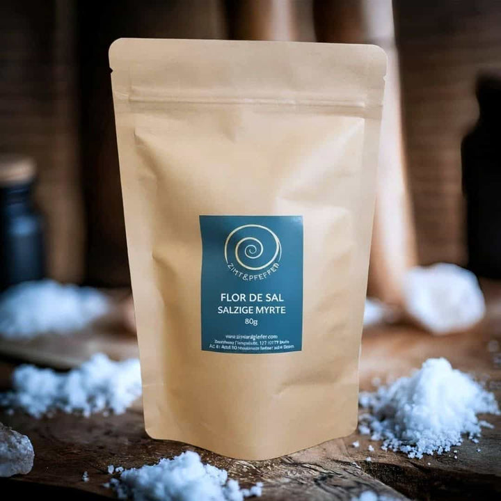 Eine Tüte  Flor de Sal Salzige Myrte mit 80 g steht auf einem Olivenholzbrett