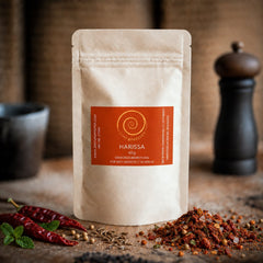 Eine Tüte Harissa 60 g auf einem Olivenholzbrett