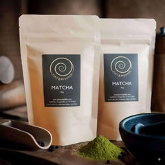 Matcha kaufen - zwei 80g Tüten Matcha auf einem Olivenholzbrett