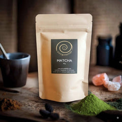 Matche kaufen - eine 80g Tüte Matcha auf einem Olivenholzbrett