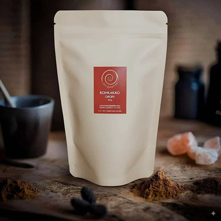 Eine 500g Tüte Rohkakao Drops auf einem Olivenblattbrett