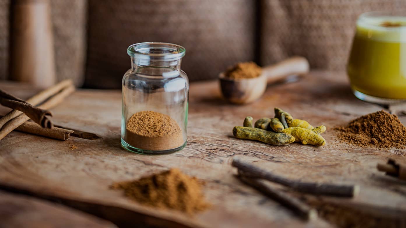 Superfoods, wie Zimt, Kurkuma und Süßholzwurzel auf einem Olivenholzbrett.