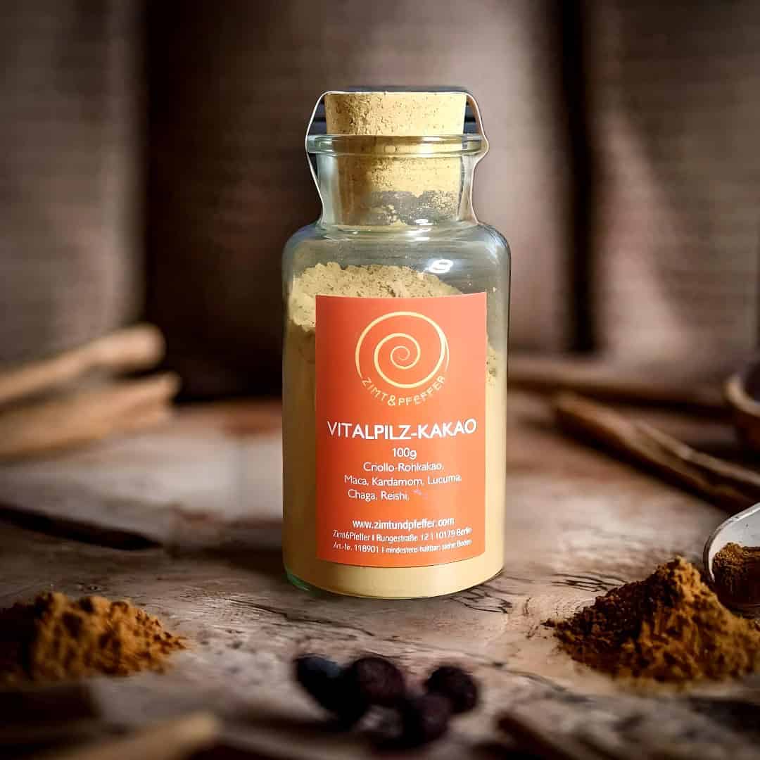 Ein Glas mit 100 g Vitalpilz-Kakao auf einem Olivenholzbrett.
