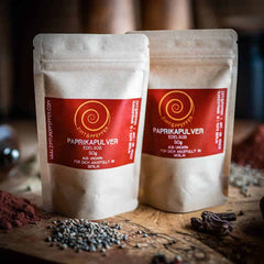 Paprika edelsüß kaufen, zwei Tüten mit je 50 g auf einem Olivenholzbrett 