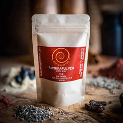 Paprika edelsüß kaufen, eine Tüte mit 50 g auf einem Olivenholzbrett