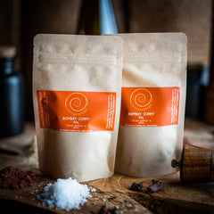 Bombay Curry von Zimt&amp;Pfeffer, zwei 40 g Tüten auf einem Olivenholzbrett