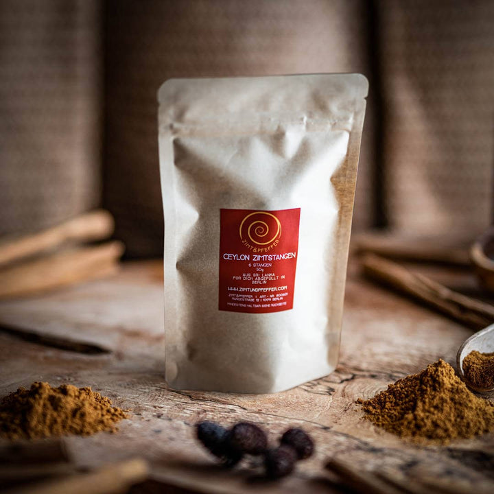 Ceylon Zimt kaufen, 6 köstliche Ceylon-Zimtstangen in einer Tüte auf einem Olivenholzbrett.