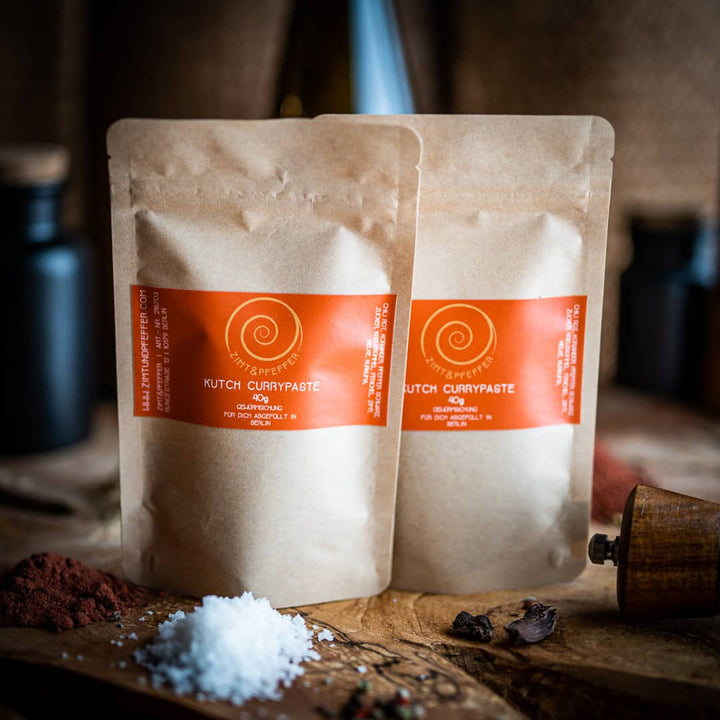 Sweet Curry von Zimt&Pfeffer, zwei 40 g Tüten auf einem Olivenholzbrett